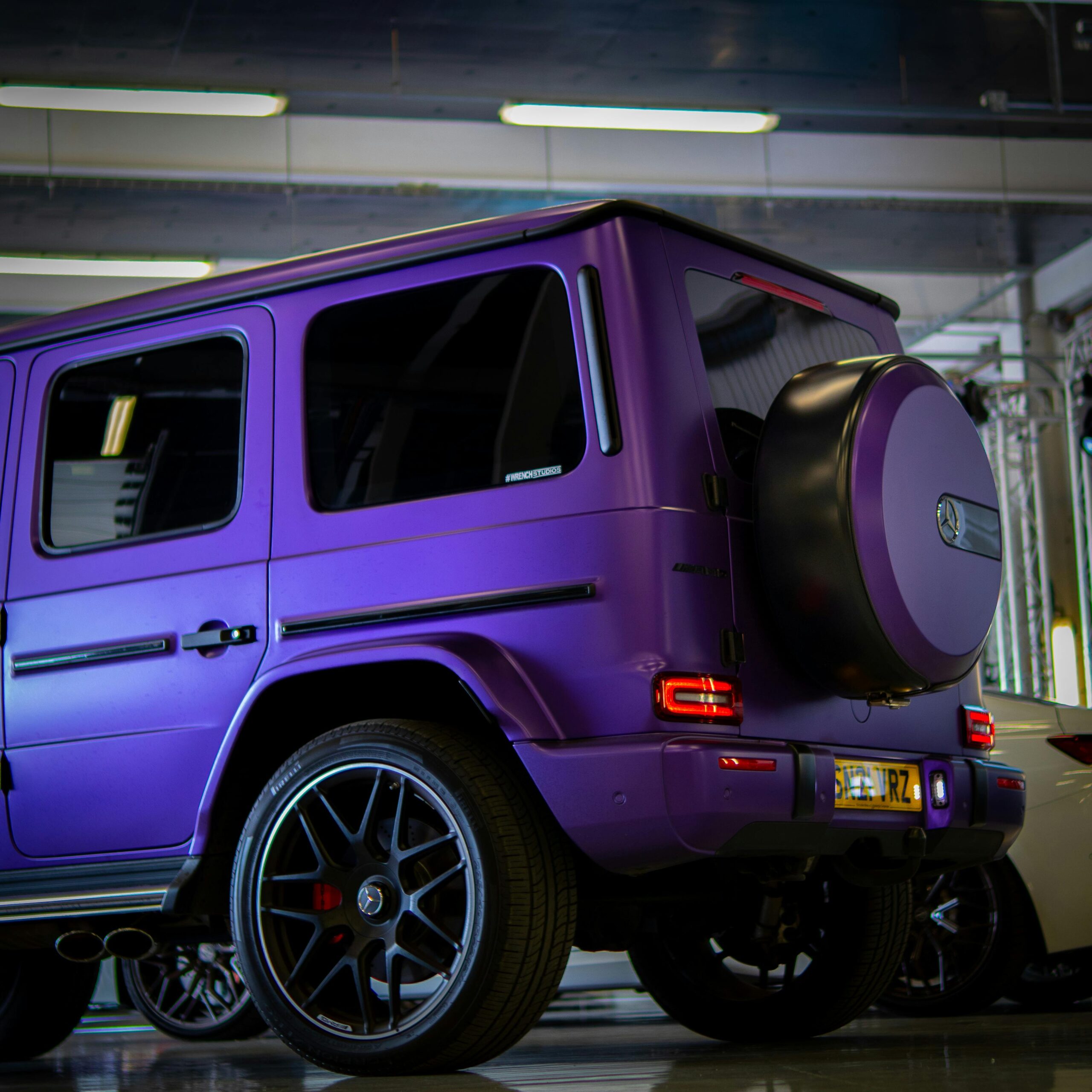 A sleek purple SUV parked indoors, showcasing its modern design and wheels.